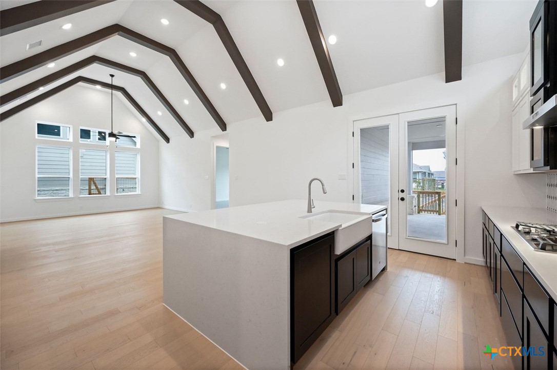 12213 Moon Pool Schertz, TX 78154 - Photo 6 of 25 a kitchen with stainless steel appliances granite countertop a kitchen island a stove a sink dishwasher and a oven with wooden floors