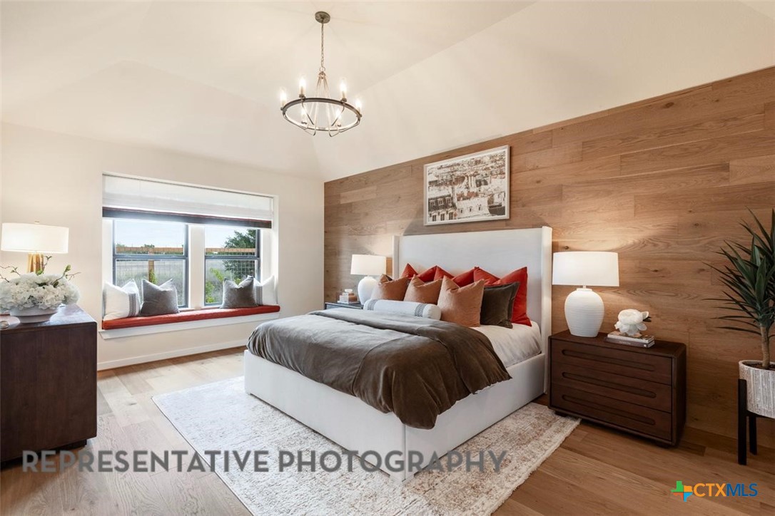 12213 Moon Pool Schertz, TX 78154 - Photo 10 of 32 a bedroom with a large bed and a chandelier