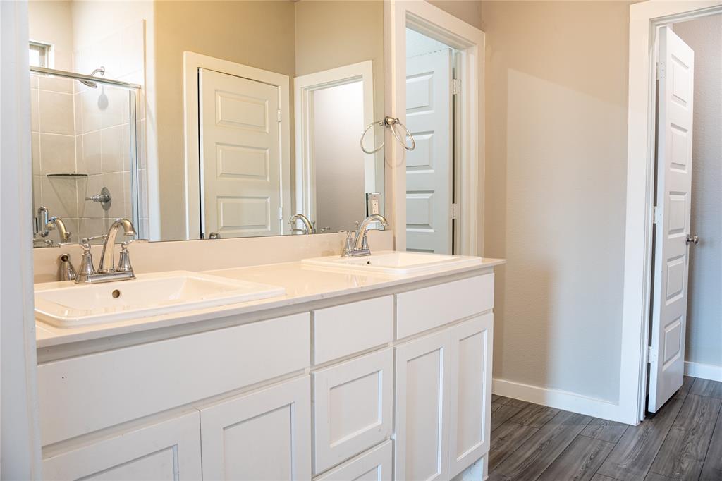 348 Braves Way Lavon, TX 75166 - Photo 13 of 29 a bathroom with a double vanity sink and a mirror
