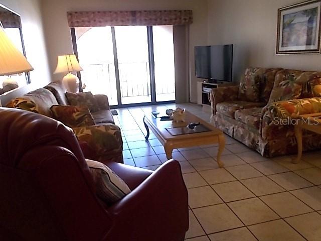 14001 Gulf Boulevard, Unit 407 Madeira Beach, FL 33708 - Photo 12 of 39 a living room with furniture and a flat screen tv