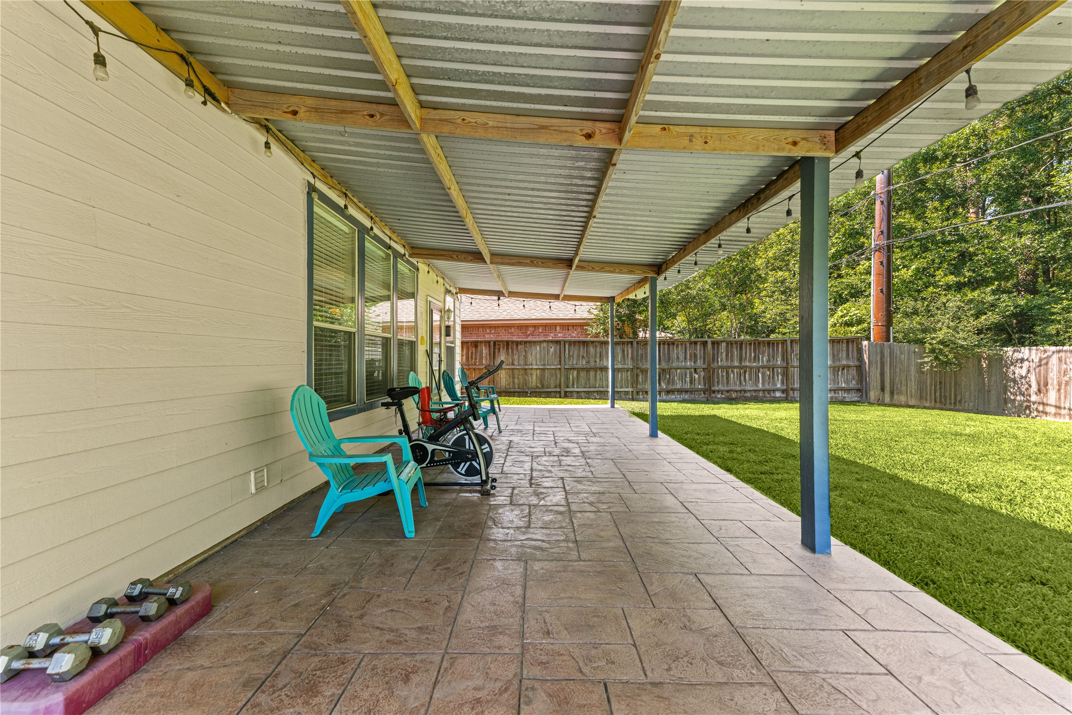 19726 Teller Boulevard Spring, TX 77388 - Photo 20 of 24 Step outside to your private outdoor oasis! This expansive covered patio offers the perfect shaded retreat for relaxing or dining al fresco. The large, paved area provides plenty of room for outdoor furniture and leads out to a beautifully maintained, lush green lawn fully enclosed by a privacy fence. Whether you're hosting a summer BBQ or enjoying a quiet morning coffee, this spacious backyard is ready for all your outdoor activities.