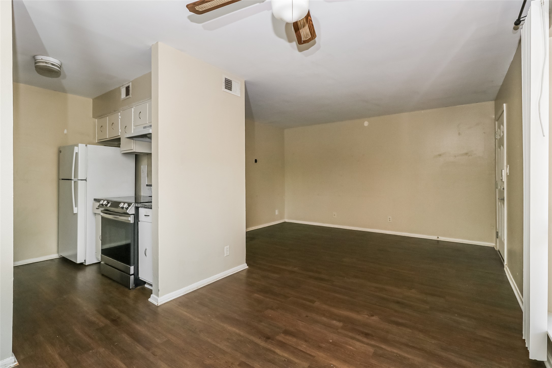 500 East Riverside Drive, Unit 135 Austin, TX 78704 - Photo 7 of 16 Unfurnished living room featuring a ceiling fan and dark wood finished floors
