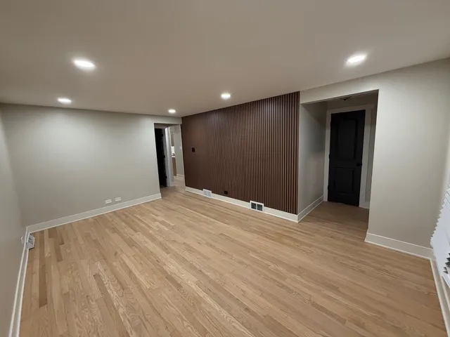 a view of an empty room with wooden floor