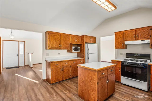 a kitchen with stainless steel appliances granite countertop a stove a sink and a refrigerator
