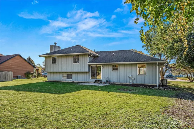 a view of a yard in front of a house with a large tree