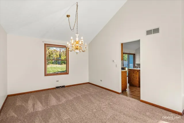 an empty room with windows and chandelier