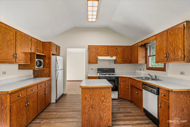 a large kitchen with stainless steel appliances granite countertop a stove a sink dishwasher and a refrigerator
