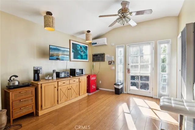 a kitchen with granite countertop a stove a sink and a refrigerator with wooden floors