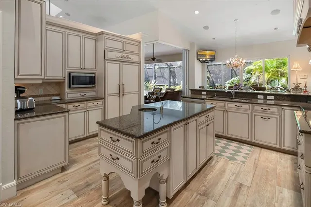 a kitchen with stainless steel appliances granite countertop a sink a stove and cabinets