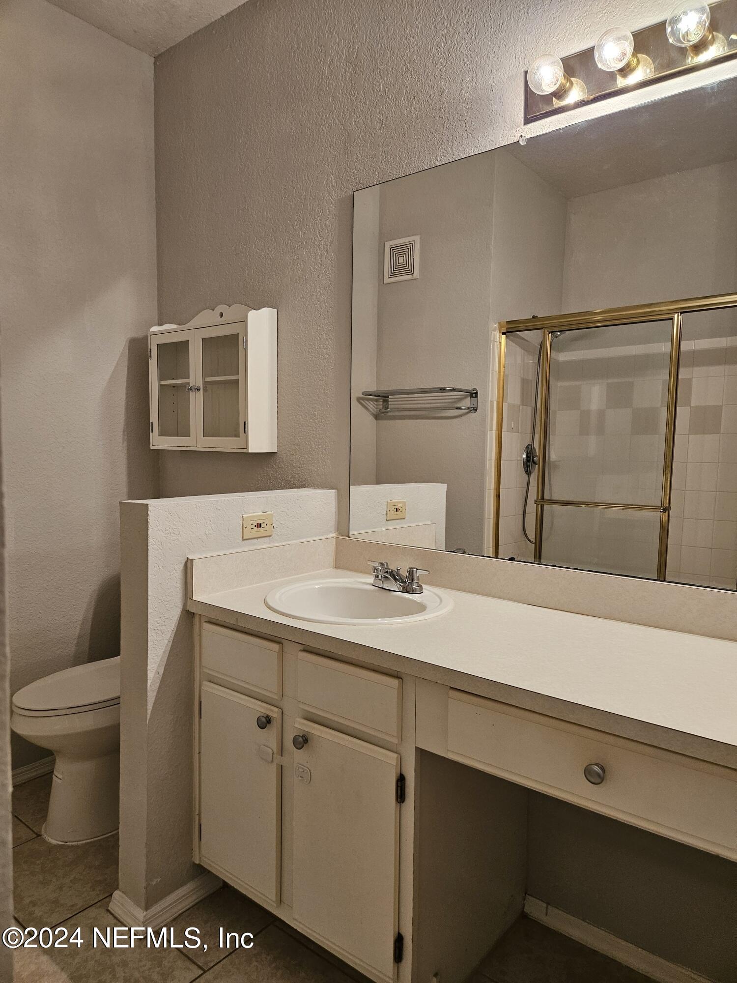 13810 Sutton Park Drive North, Unit 916 Jacksonville, FL 32224 - Photo 10 of 17 a bathroom with a sink a toilet and mirror