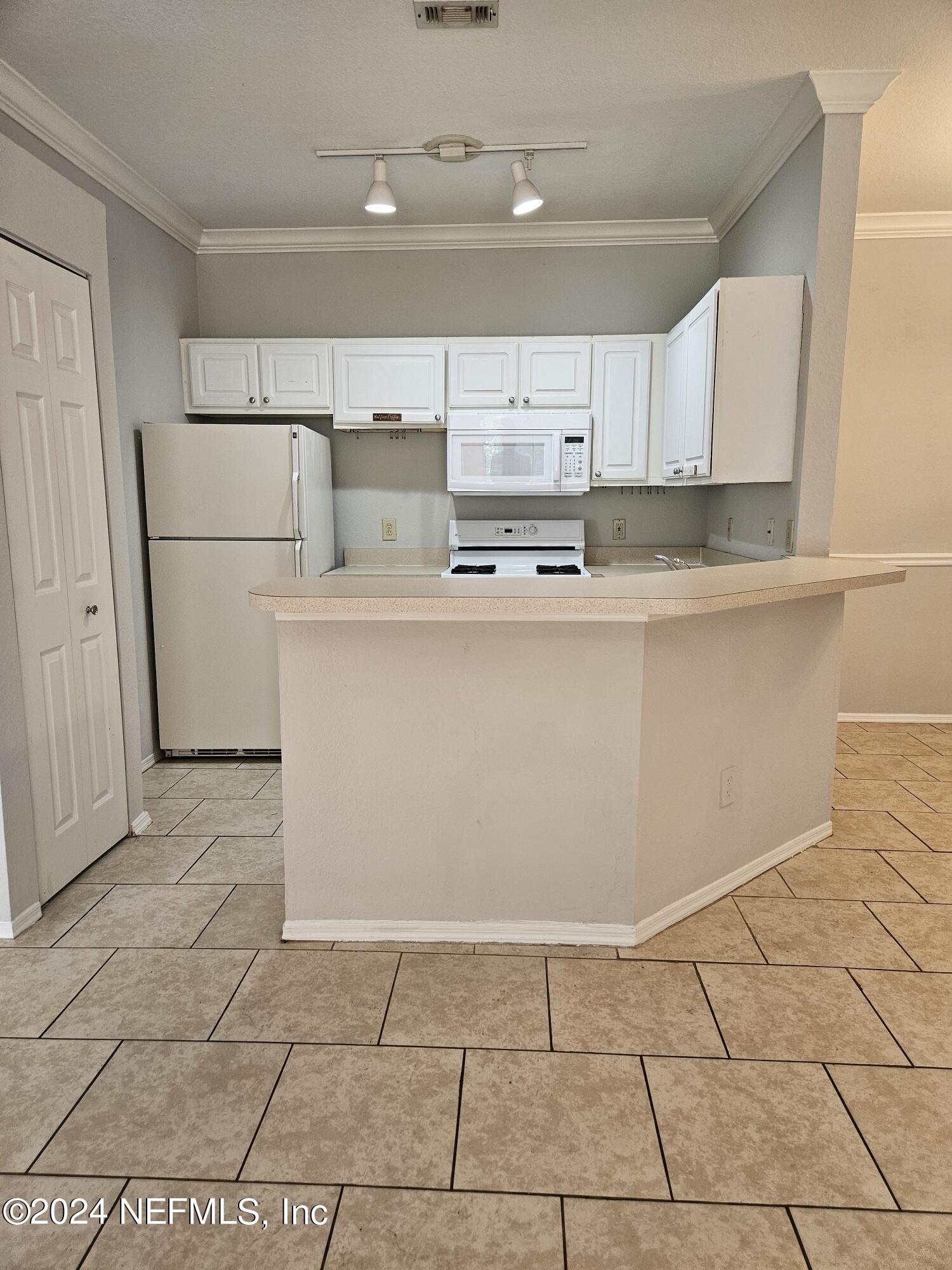 a kitchen with stainless steel appliances a sink counter top space cabinets and a window