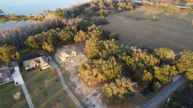an aerial view of ocean and residential houses with outdoor space
