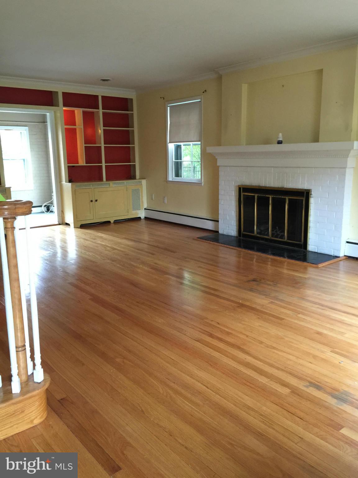 104 Croydon Road Baltimore, MD 21212 - Photo 2 of 13 an empty room with wooden floor fireplace and windows