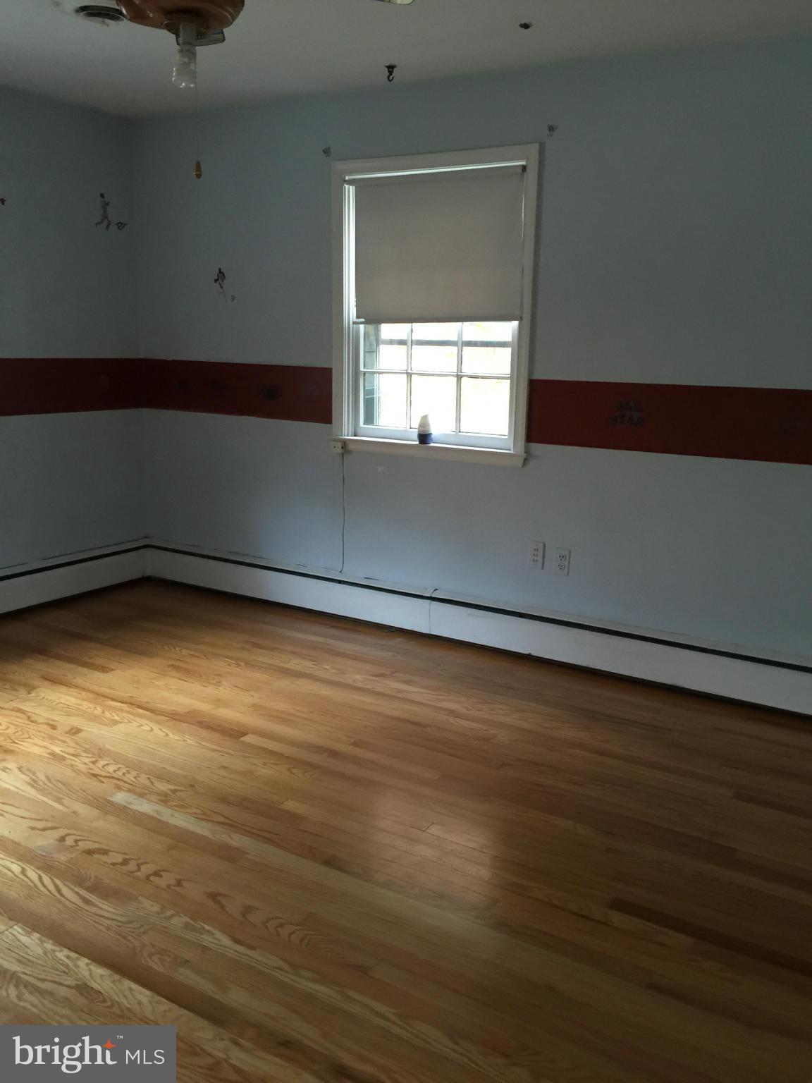 104 Croydon Road Baltimore, MD 21212 - Photo 6 of 13 a view of an empty room with wooden floor and a window