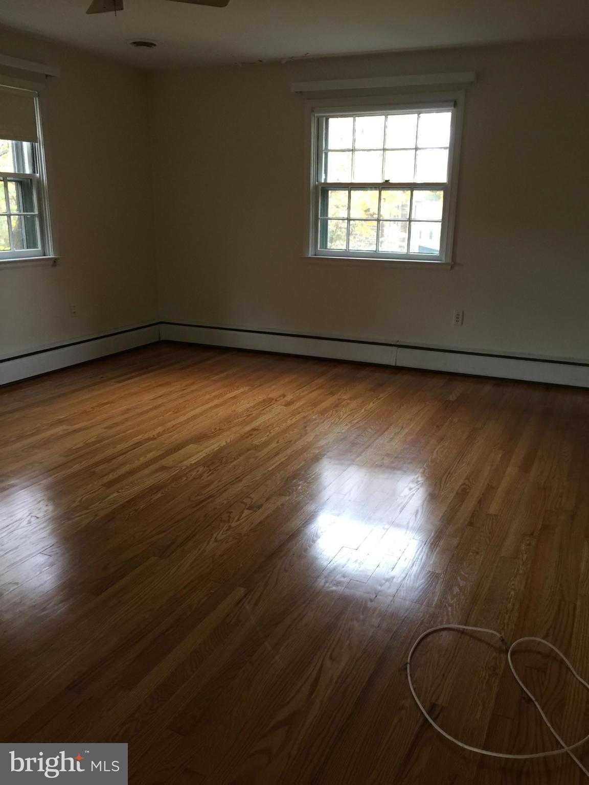 104 Croydon Road Baltimore, MD 21212 - Photo 8 of 13 an empty room with wooden floor and windows