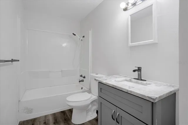 a bathroom with a sink toilet vanity and shower