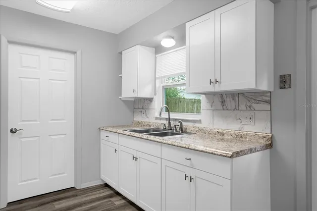a bathroom with a granite countertop sink and a white cabinet