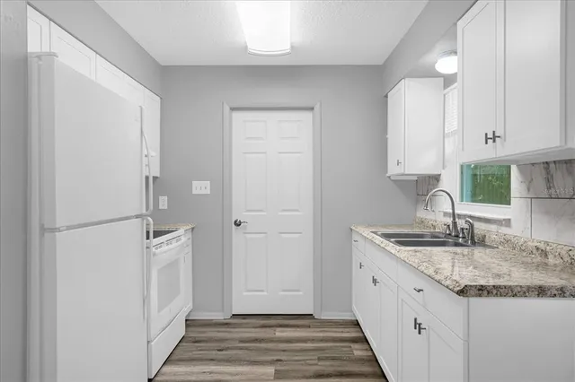 a view of a kitchen with wooden floor and a window