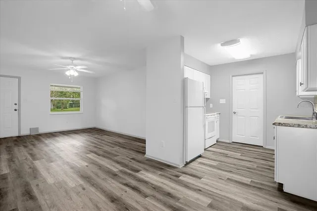 a view of a kitchen with wooden floor a sink and a window