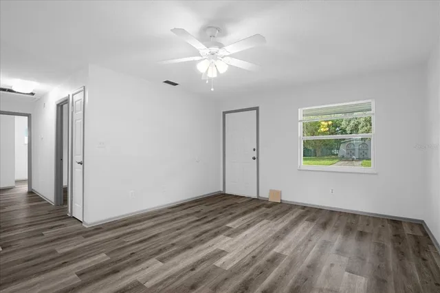 a view of an empty room with wooden floor