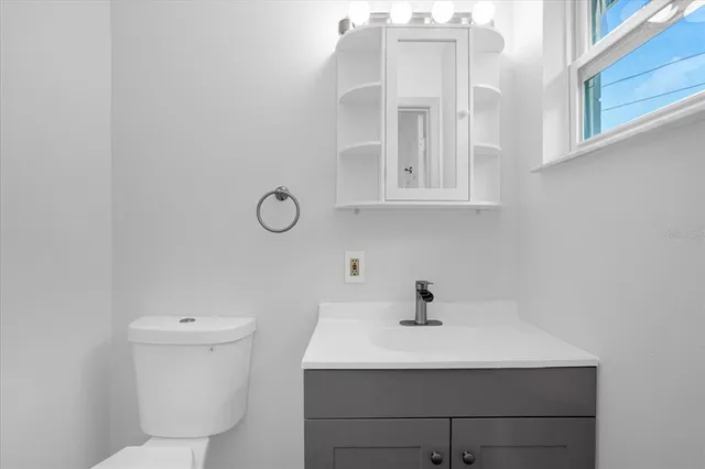 a bathroom with a sink a toilet and mirror