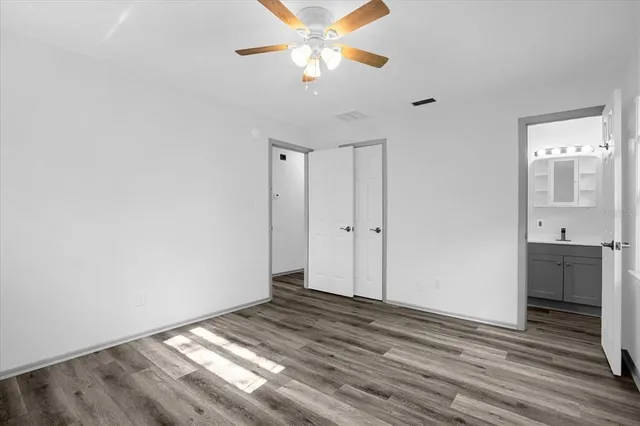 a view of a livingroom with wooden floor and a ceiling fan