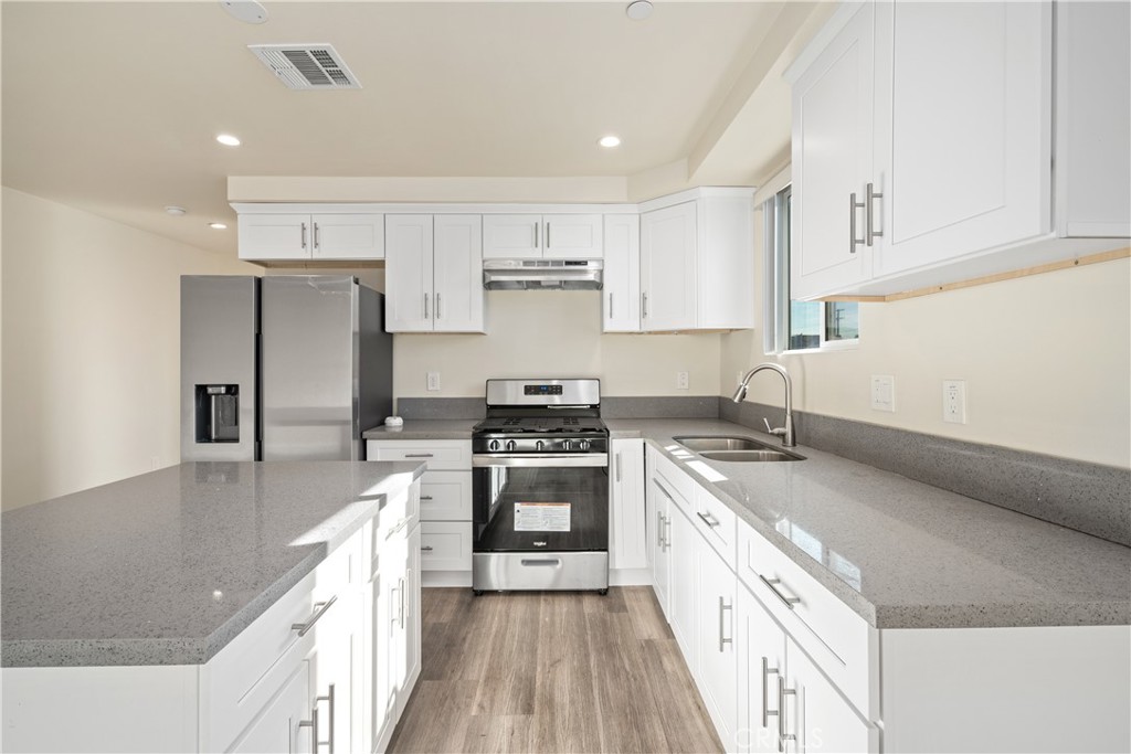 1822 Orchard Avenue, Unit 1822 Los Angeles, CA 90006 - Photo 4 of 17 a kitchen with stainless steel appliances granite countertop a sink stove and refrigerator