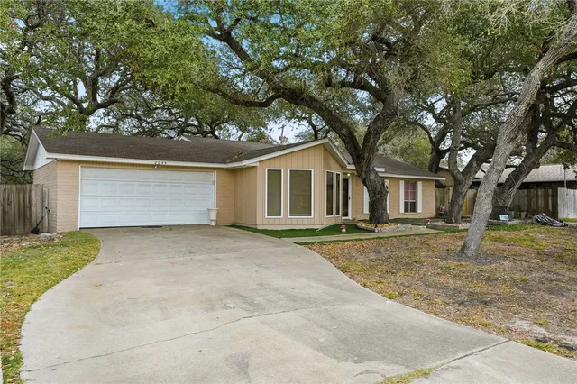 a view of a yard in front of a house with large tree