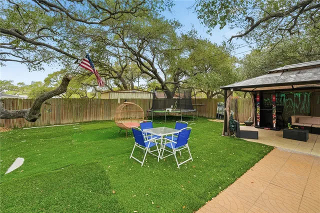 a view of a house with a yard chairs and table in the patio