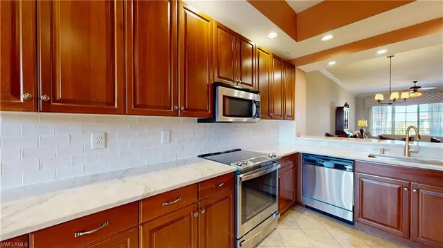 a kitchen with stainless steel appliances granite countertop a sink a stove and a microwave