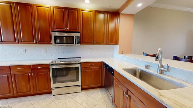 a kitchen with stainless steel appliances granite countertop a sink and a microwave