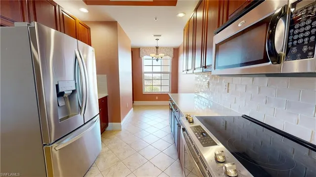 a kitchen with stainless steel appliances granite countertop a refrigerator and a stove