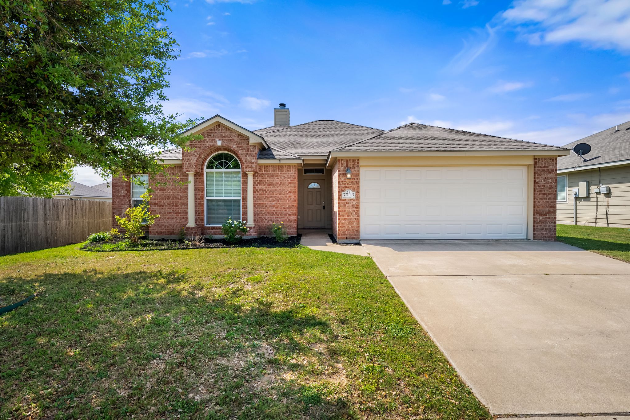 7719 Fieldstone Drive Temple, TX 76502 - Photo 2 of 37 Ranch-style home featuring a chimney, a garage, concrete driveway, brick siding, and roof with shingles
