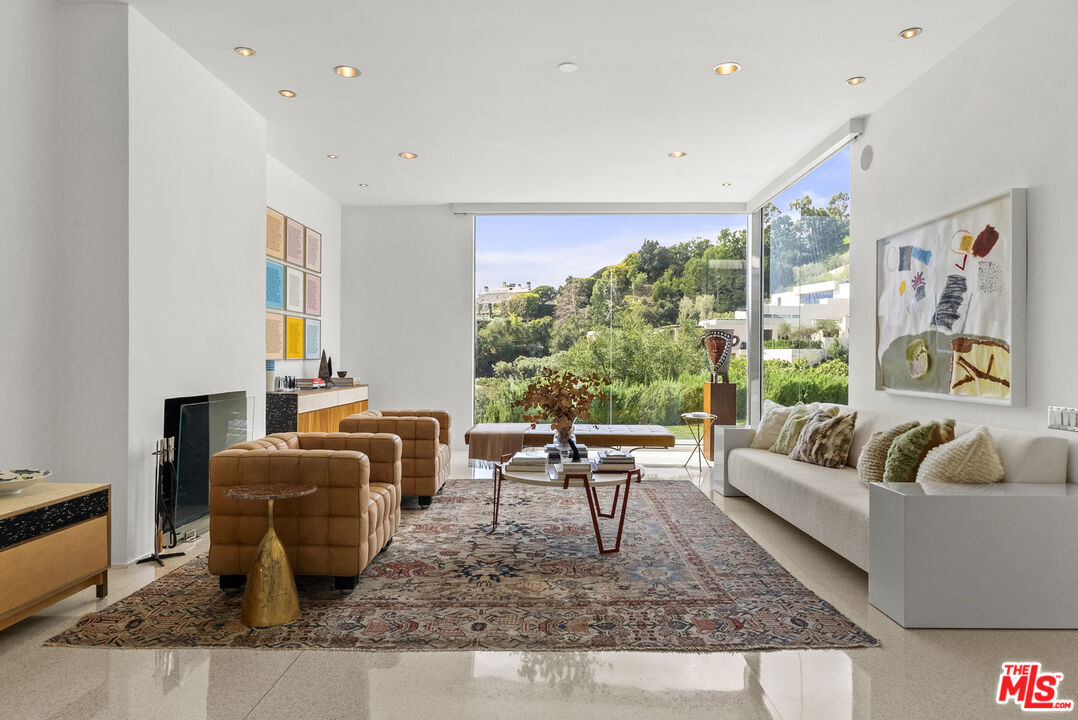 10899 Chalon Road Los Angeles, CA 90077 - Photo 11 of 34 a living room with furniture large window and a table
