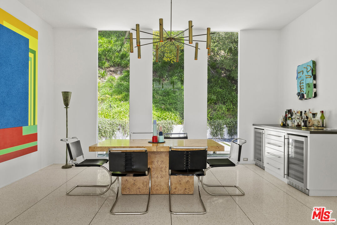 10899 Chalon Road Los Angeles, CA 90077 - Photo 13 of 34 a dining room with furniture a large window and a rug