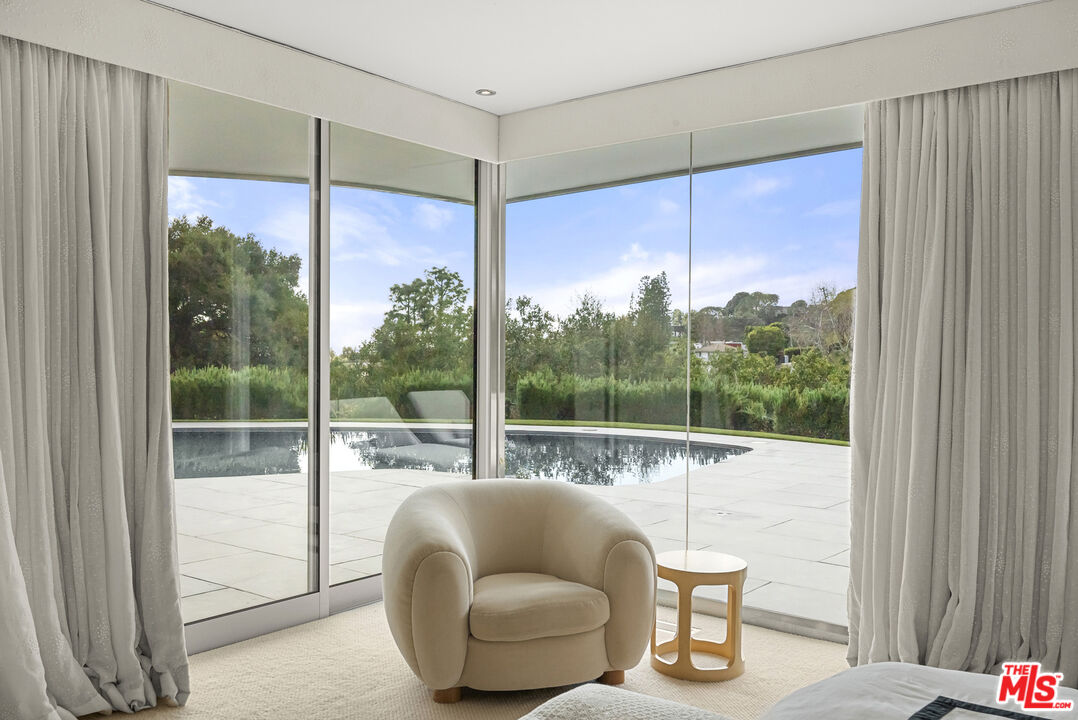 10899 Chalon Road Los Angeles, CA 90077 - Photo 18 of 34 a living room with furniture and a floor to ceiling window