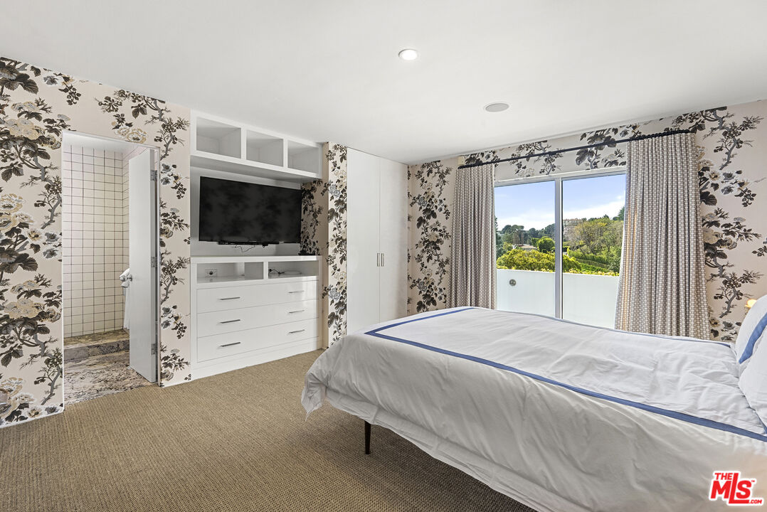 10899 Chalon Road Los Angeles, CA 90077 - Photo 24 of 34 a bedroom with a bed and a flat tv screen on dresser