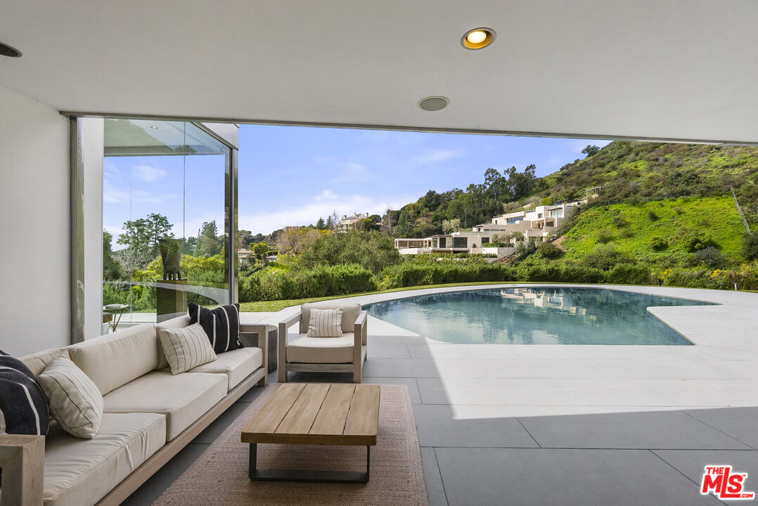 10899 Chalon Road Los Angeles, CA 90077 - Photo 28 of 34 a view of a living room with a couch and floor to ceiling window