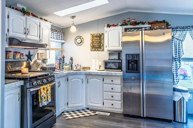 a kitchen with stainless steel appliances granite countertop a stove and cabinets