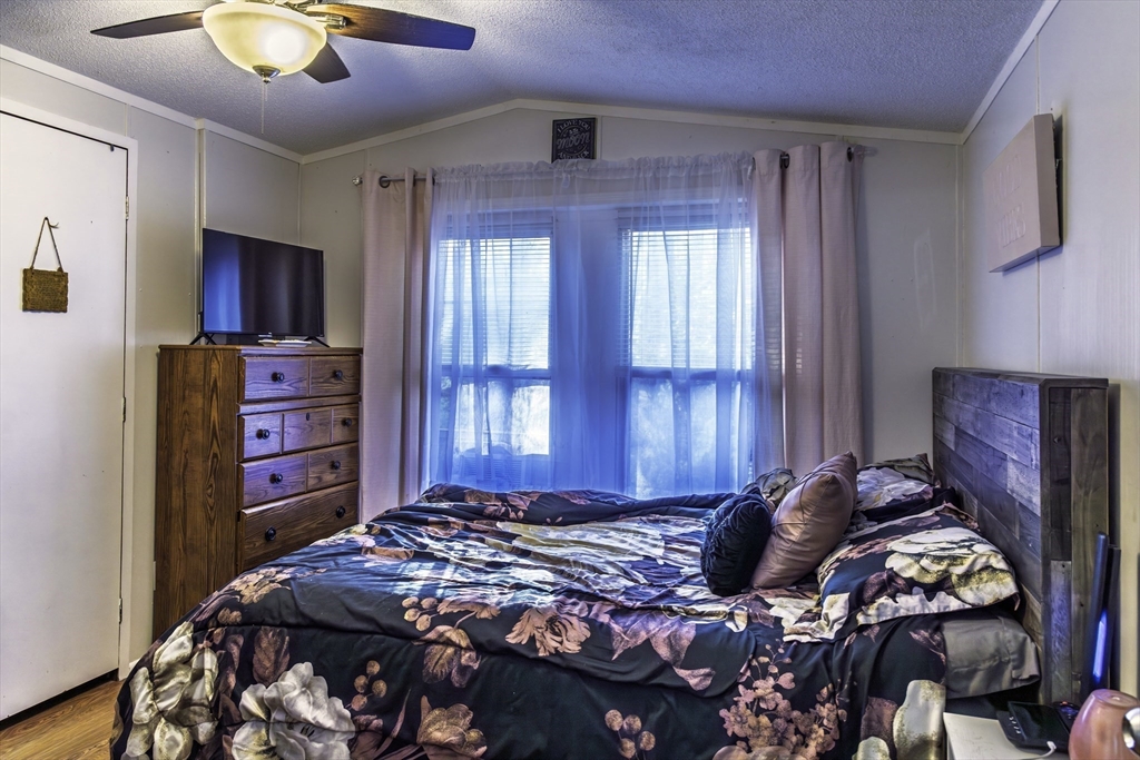 18 Maple Street, Unit 30 Pepperell, MA 01463 - Photo 11 of 19 a bedroom with a bed and a chandelier