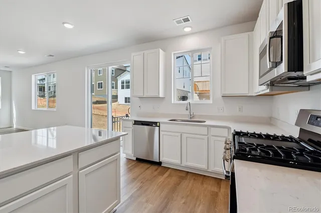 a kitchen with granite countertop a sink stove and cabinets