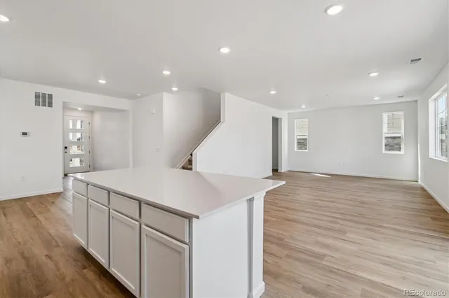a view of a kitchen with wooden floor and white doors