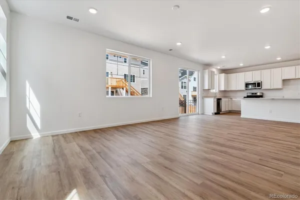 a view of a kitchen with wooden floor and electronic appliances