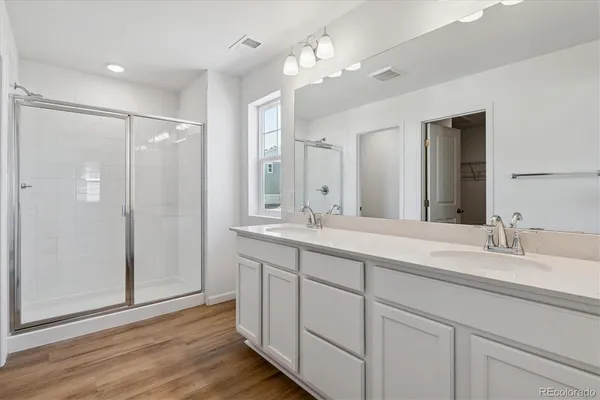 a bathroom with double vanity sinks and a mirror