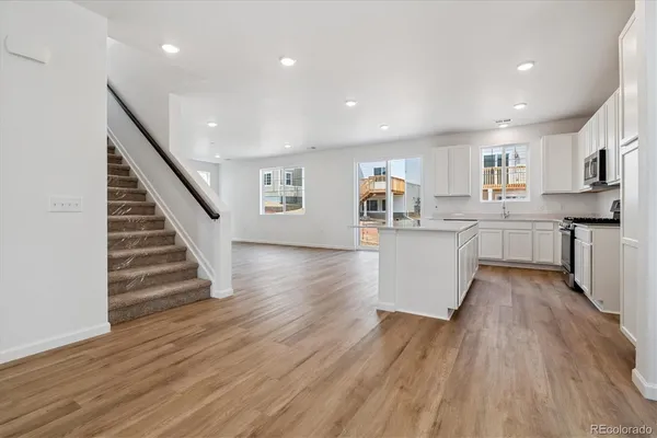 a view of kitchen with wooden floor and electronic appliances