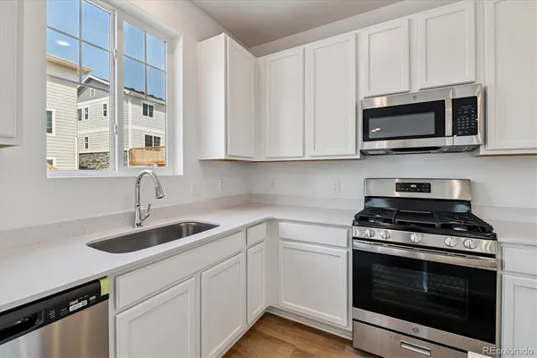 a kitchen with stainless steel appliances granite countertop a sink a stove and microwave