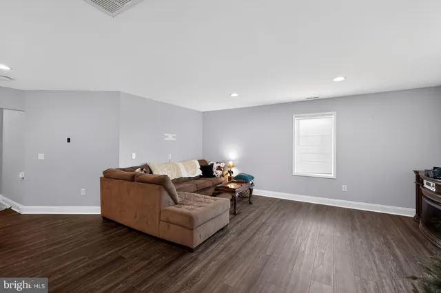 a living room with furniture and a hard wood floor