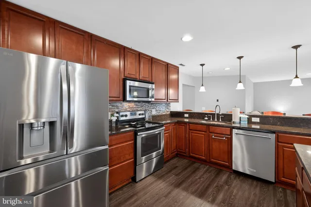 a kitchen with wooden cabinets and stainless steel appliances