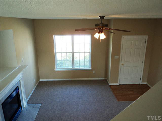 6822 Paint Rock Lane Raleigh, NC 27610 - Photo 8 of 11 a view of an empty room with a window and a fireplace