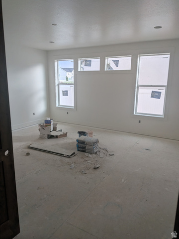 2771 West Aurora Avenue Mapleton, UT 84664 - Photo 15 of 39 Bright interior space featuring multiple windows, recessed ceiling lighting, and a dark wood-finish door frame